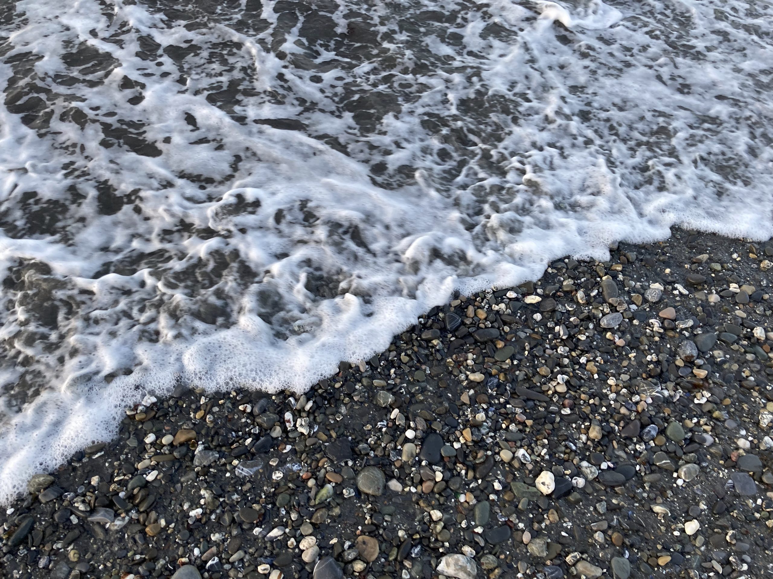 Photo d’une vague se retirant d’une plage de galets à Matane.