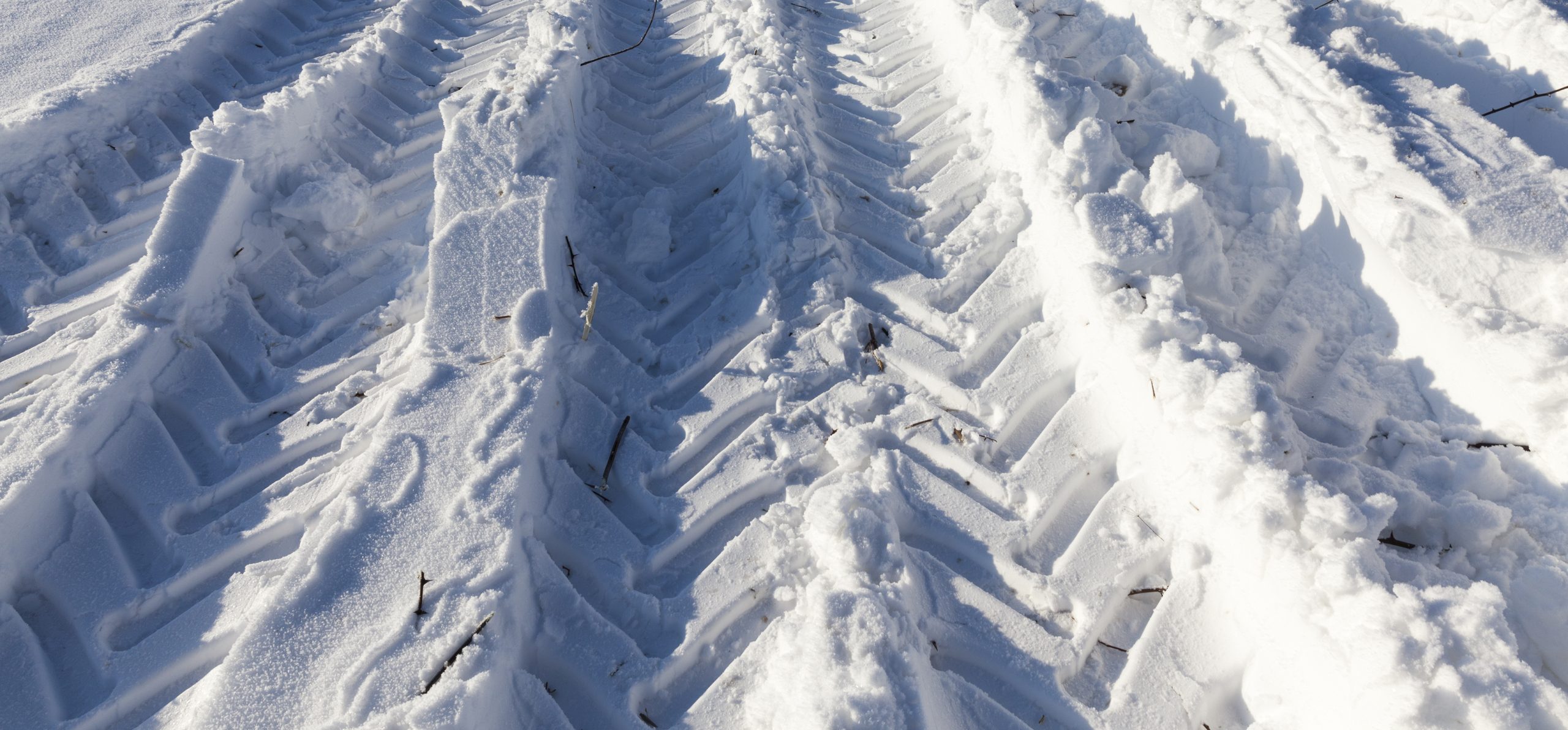 Des traces de pneu de véhicule lourd dans la neige. 