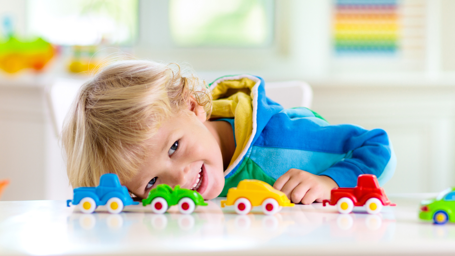 Un enfant jouant des petits véhicules colorés